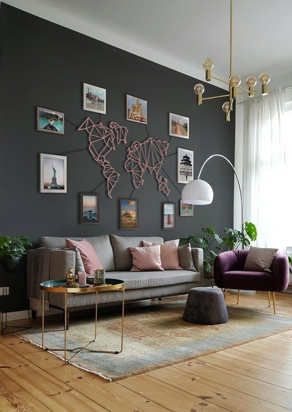 a living room with grey walls and pictures on the wall above the couch, coffee table