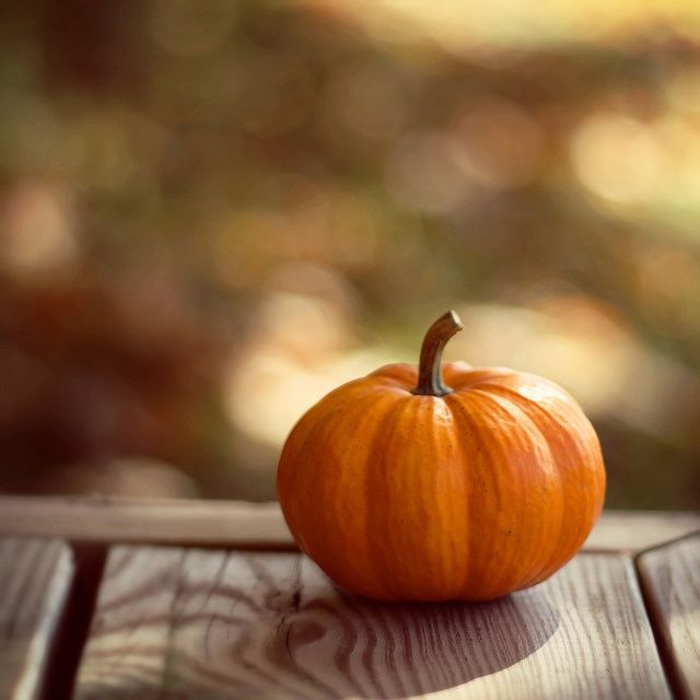 an orange pumpkin sitting on top of a wooden table