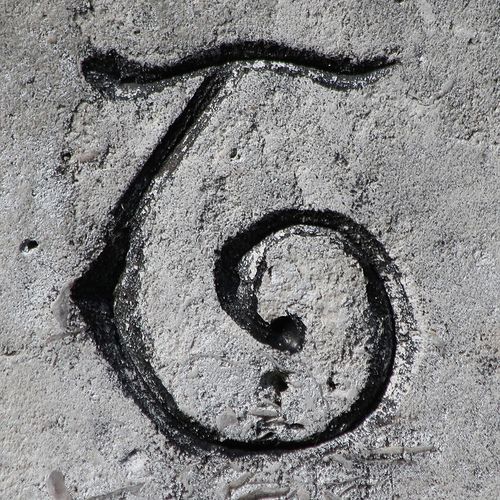 the letter s is drawn in sand with a black marker on it's side