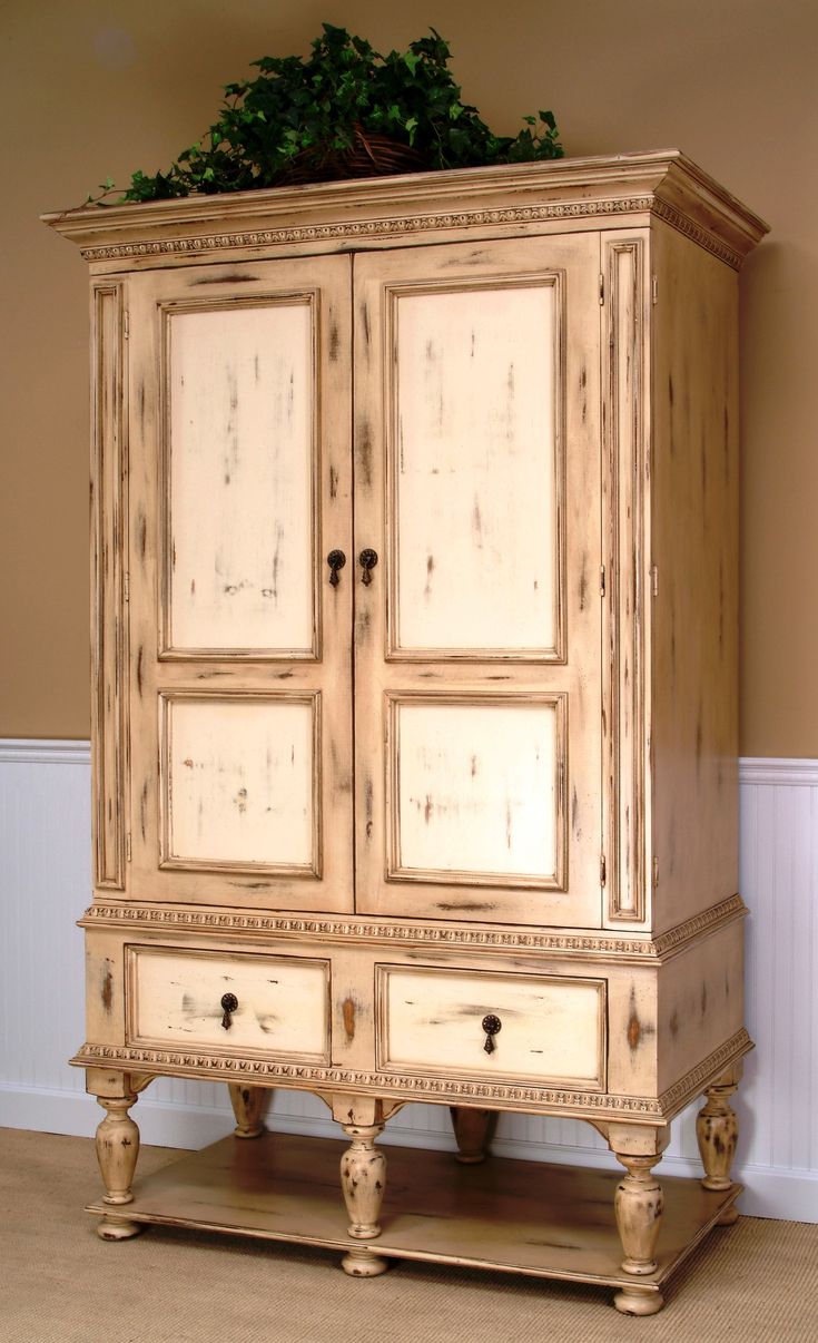 an old wooden cabinet with two doors and three drawers on the bottom, in a living room