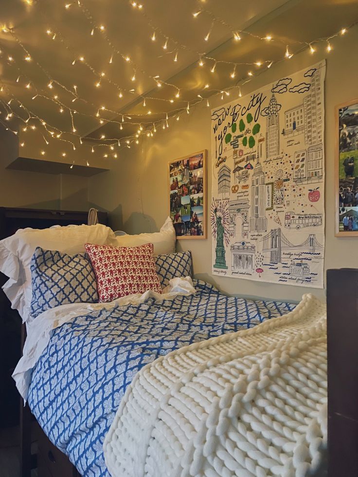 a bedroom with lights strung from the ceiling and pictures on the wall above the bed