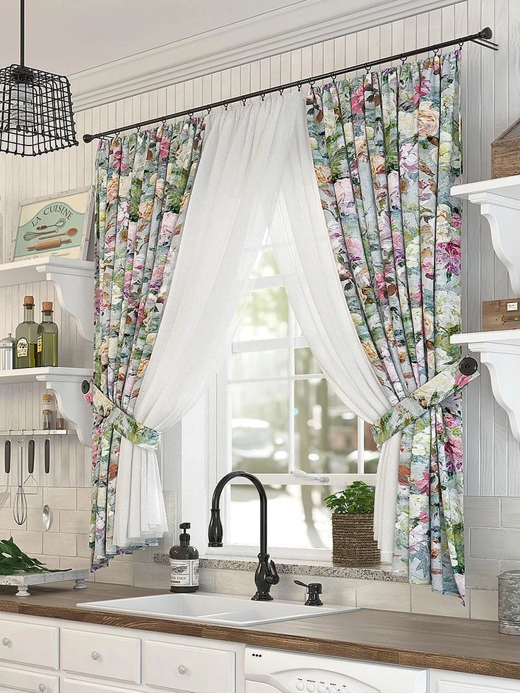 the kitchen is decorated in white and has pink flowers on the curtained windowsill