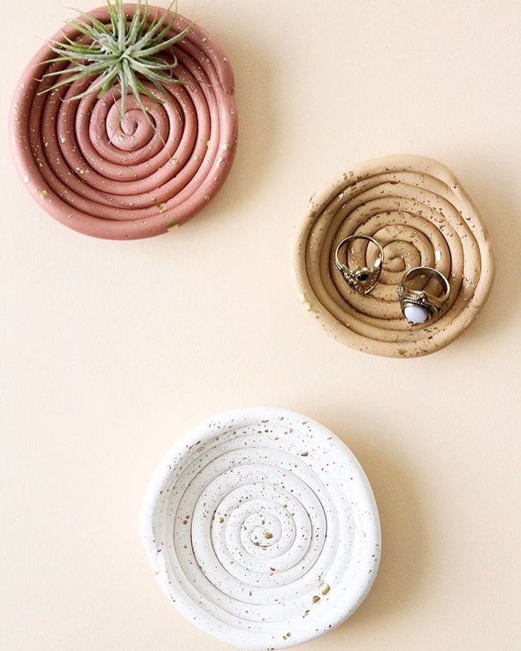 three small pots with plants in them on a white surface next to two smaller ones