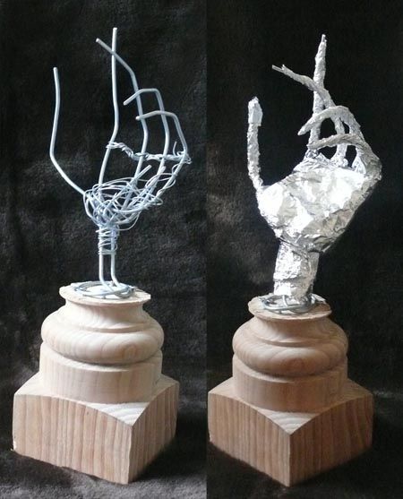 two sculptures made out of wood and tin foil