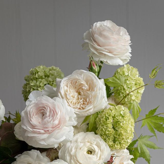 a vase filled with white and green flowers