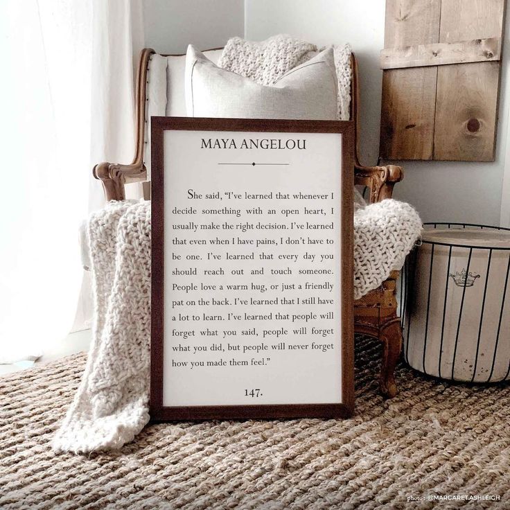 a wooden frame sitting on top of a rug next to a chair and pillow in front of a window