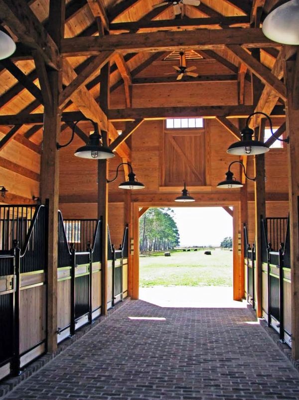 the inside of a horse barn with stalls and lights