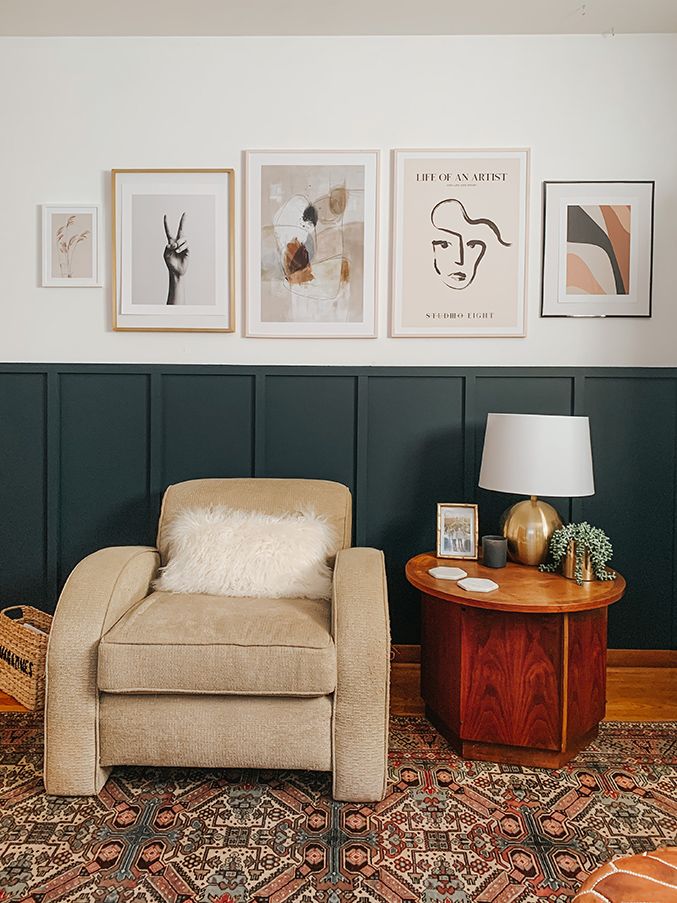 a living room with pictures on the wall and a chair next to a table in front of it