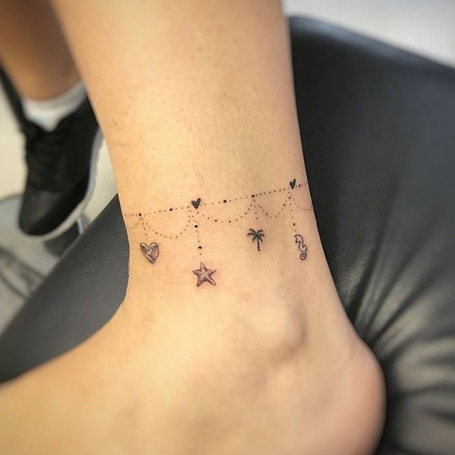 a woman's foot with small stars and hearts on the bottom of her ankle