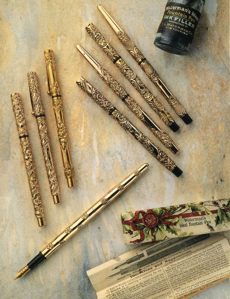 several different types of pens sitting on top of a table next to an empty bottle