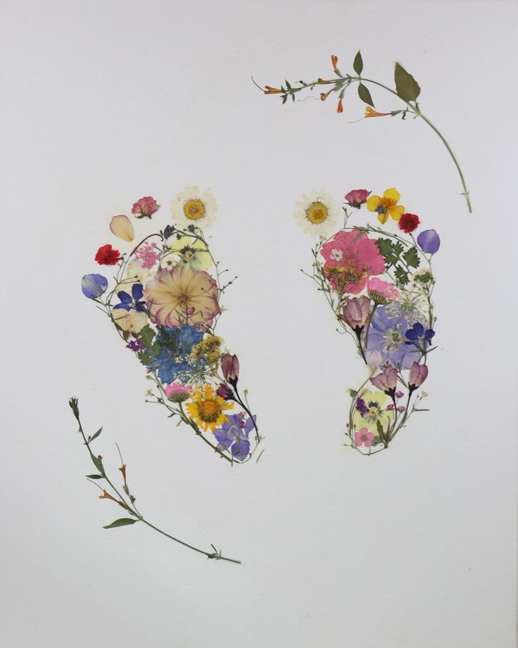 an arrangement of flowers arranged on top of each other in the shape of two footprints