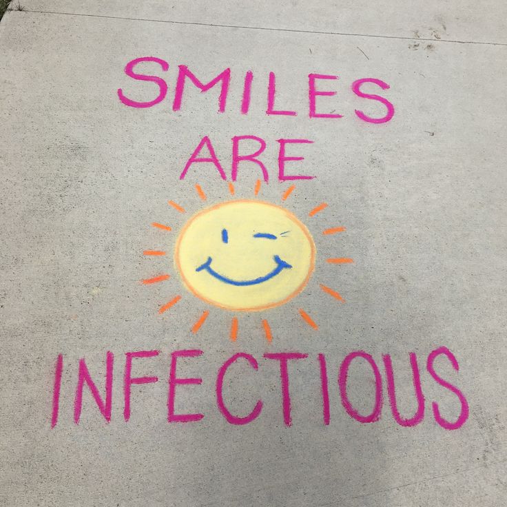 a sidewalk with chalk writing on it that says, smiles are infectious and an image of a smiling sun