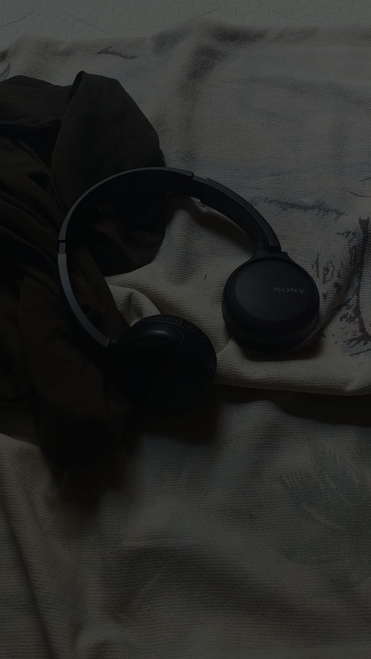 headphones laying on top of a white sheet