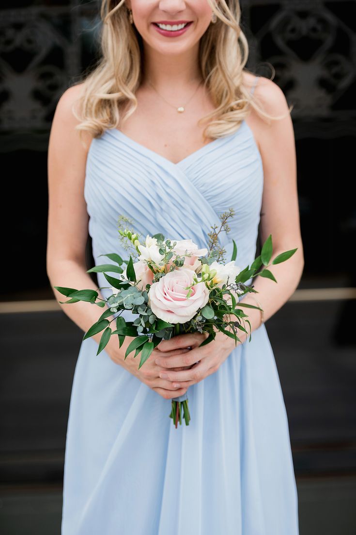 a woman in a blue dress holding a bouquet