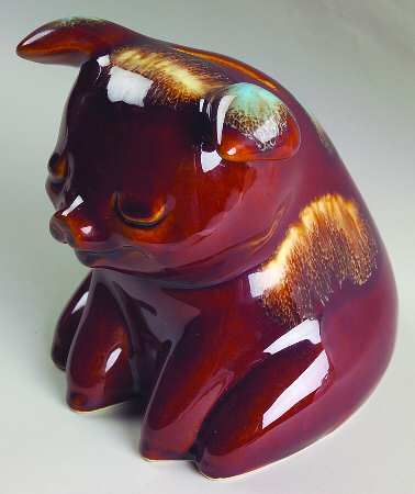 a glass figurine shaped like a cat sitting on its hind legs and looking to the side