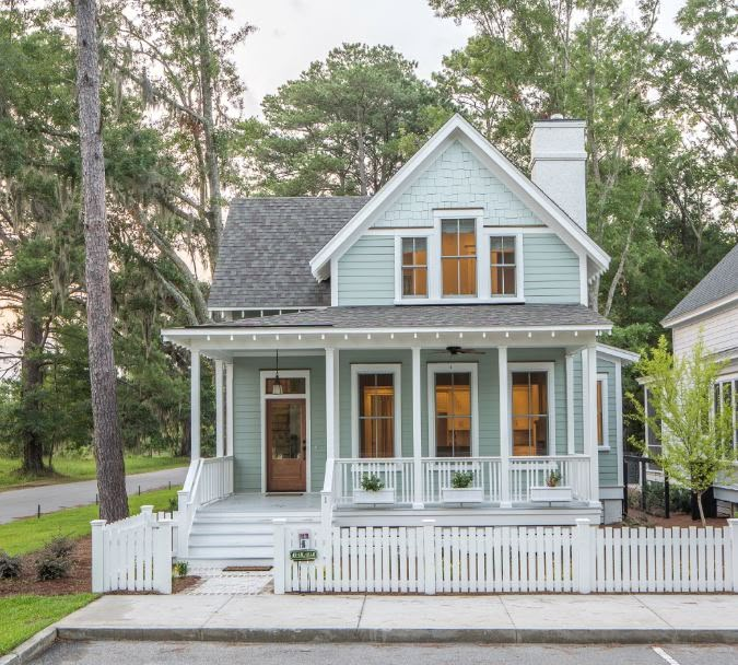 a house with white picket fence and trees in the background