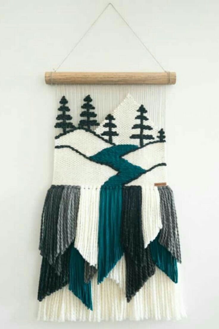 the wall hanging is decorated with green, white and black fringes that have trees on them