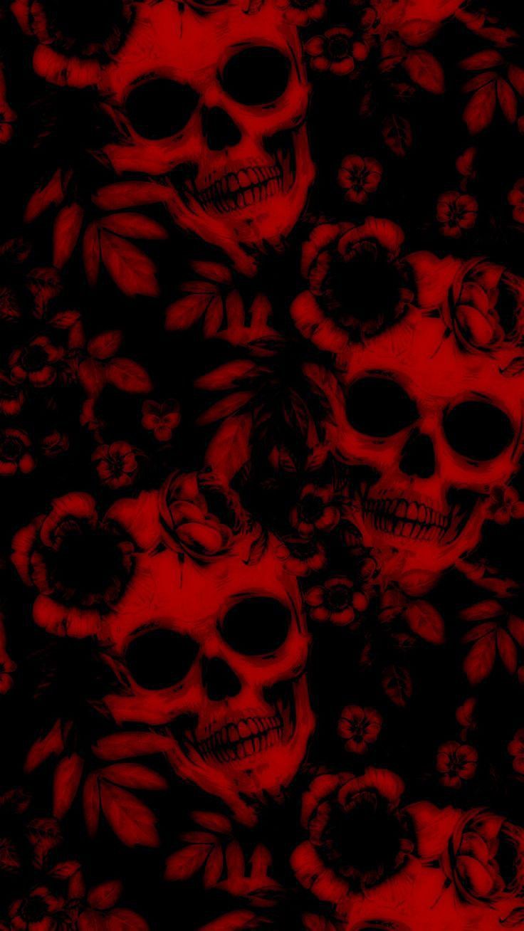 a bunch of skulls that are all red and black with flowers on them in the background