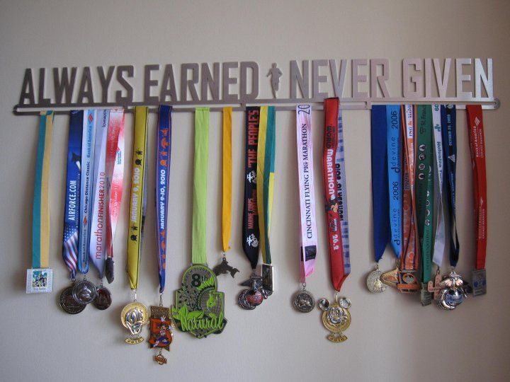 a bunch of medals are hanging on a wall with the words earn and never given