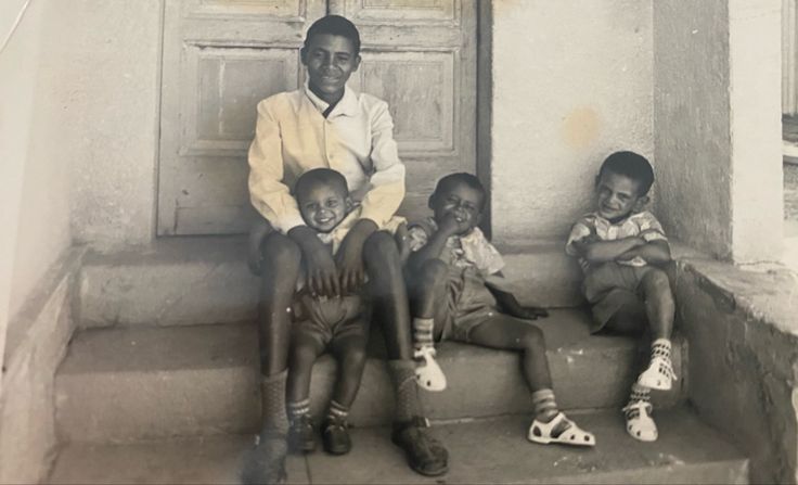 an old black and white photo of children sitting on steps