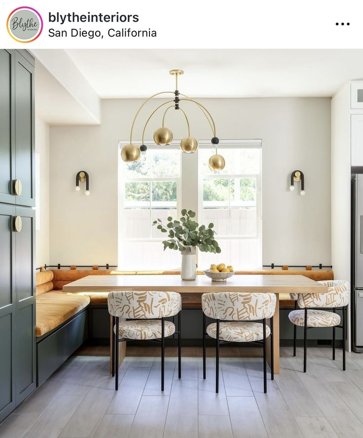 a dining room table with four chairs and a potted plant