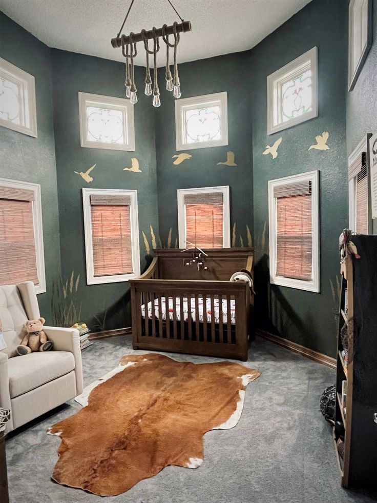 a baby's room decorated in green and brown with white trimmings on the walls