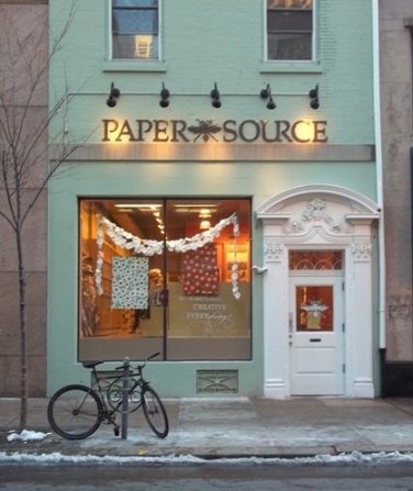 there is a bike parked in front of the paper source store