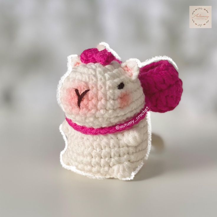 a crocheted toy with a pink bow on it's head and ears