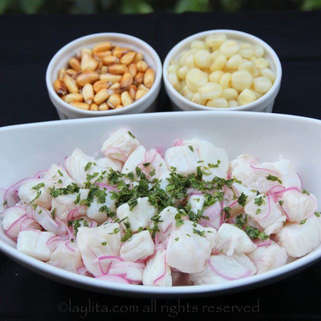 a white bowl filled with food next to two bowls full of nuts and other foods