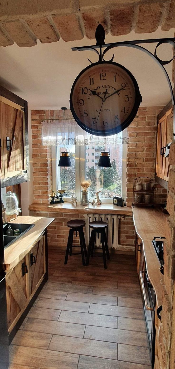 a kitchen with a large clock hanging from the ceiling