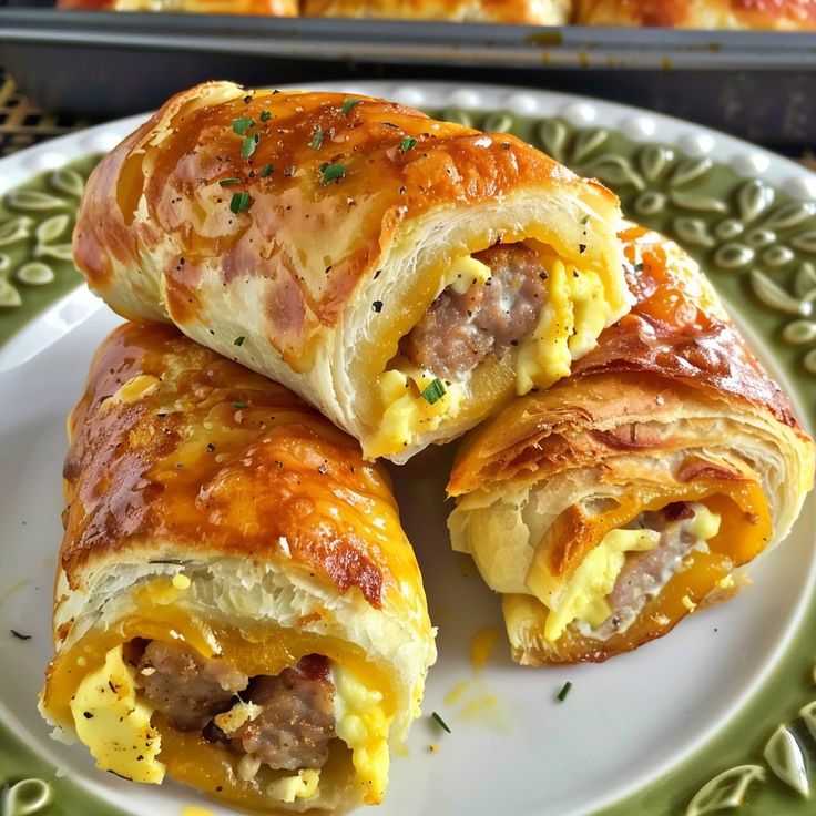 three breakfast rolls on a plate with cheese and meat