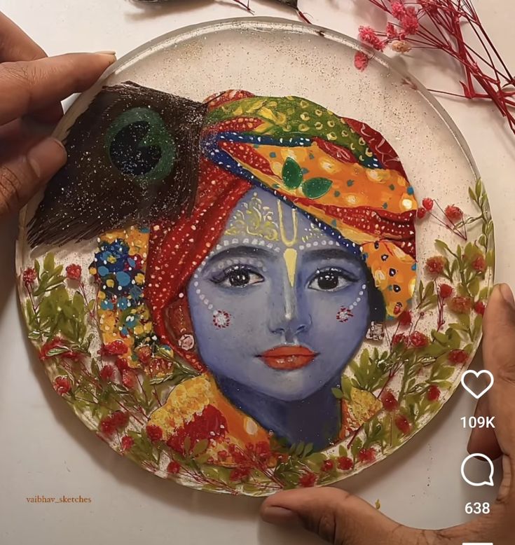 two hands are holding a plate with a painting on it and another hand is touching the plate