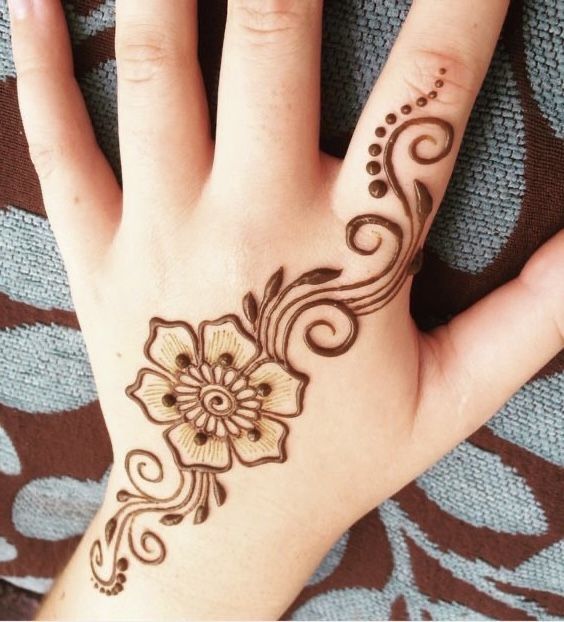 a woman's hand with hennap on it and flowers painted on the palm