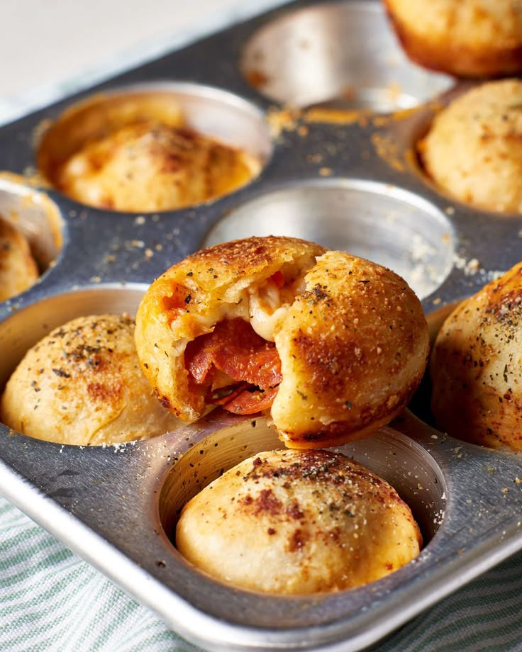 a muffin tin filled with mini pizzas