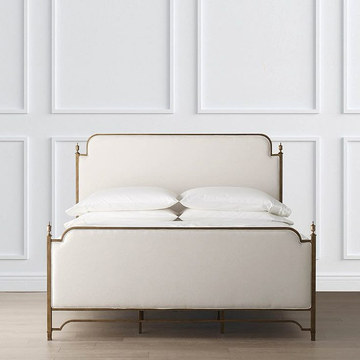 a bed with white sheets and pillows on it