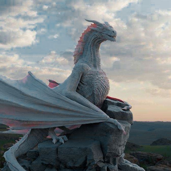 a white dragon statue sitting on top of a rock