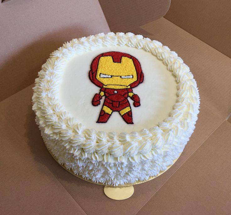 a birthday cake with an iron man design on the frosting and white icing