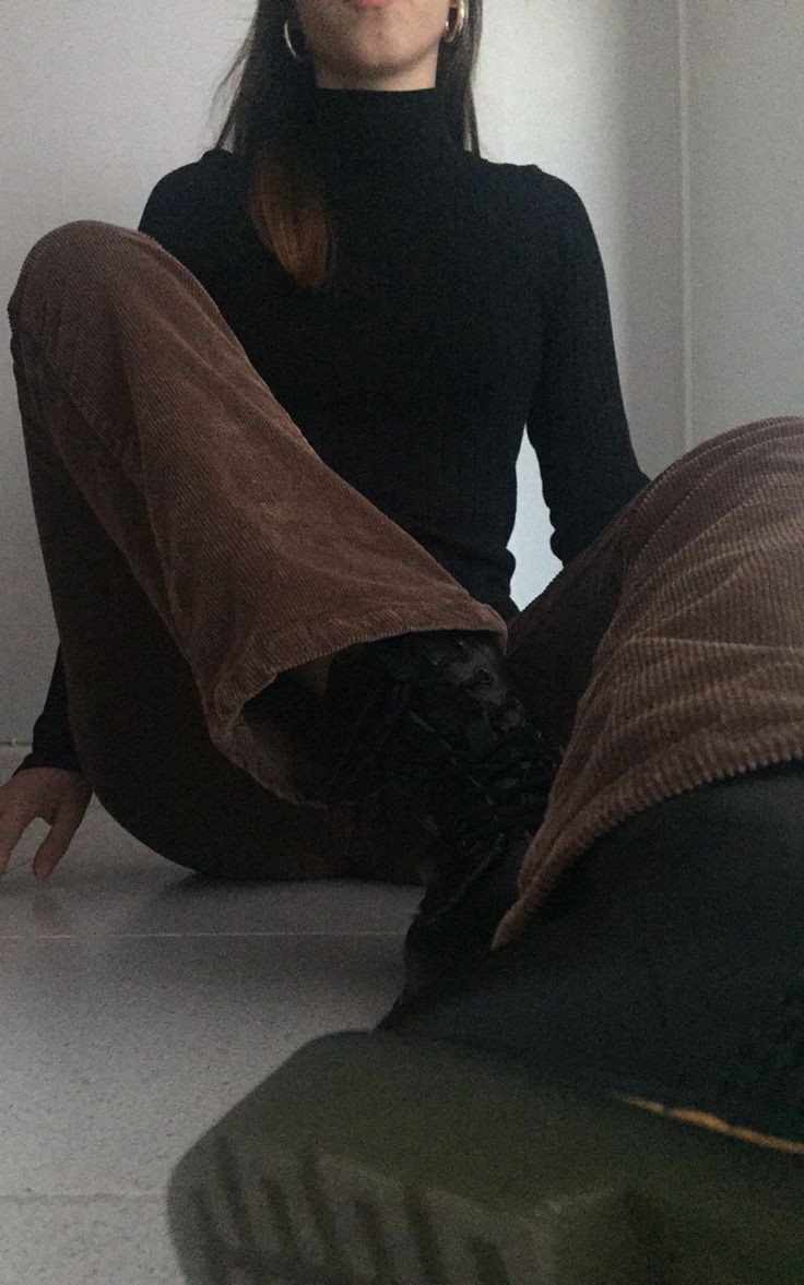 a woman is sitting on the floor with her legs crossed and looking at the camera