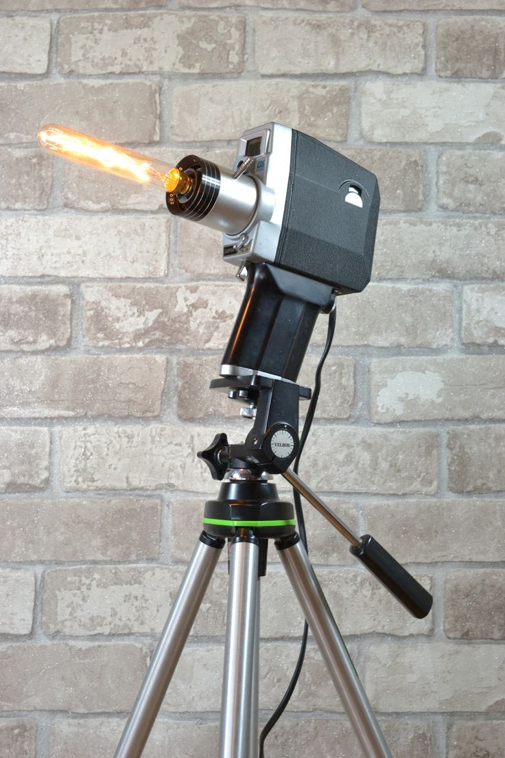 a telescope on a tripod with a light coming out of it's side