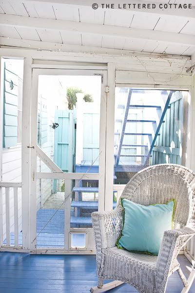 a rocking chair sitting on top of a wooden floor next to a door and window