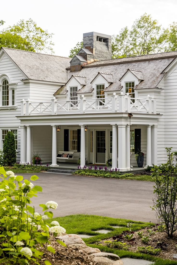 a large white house sitting on top of a lush green field