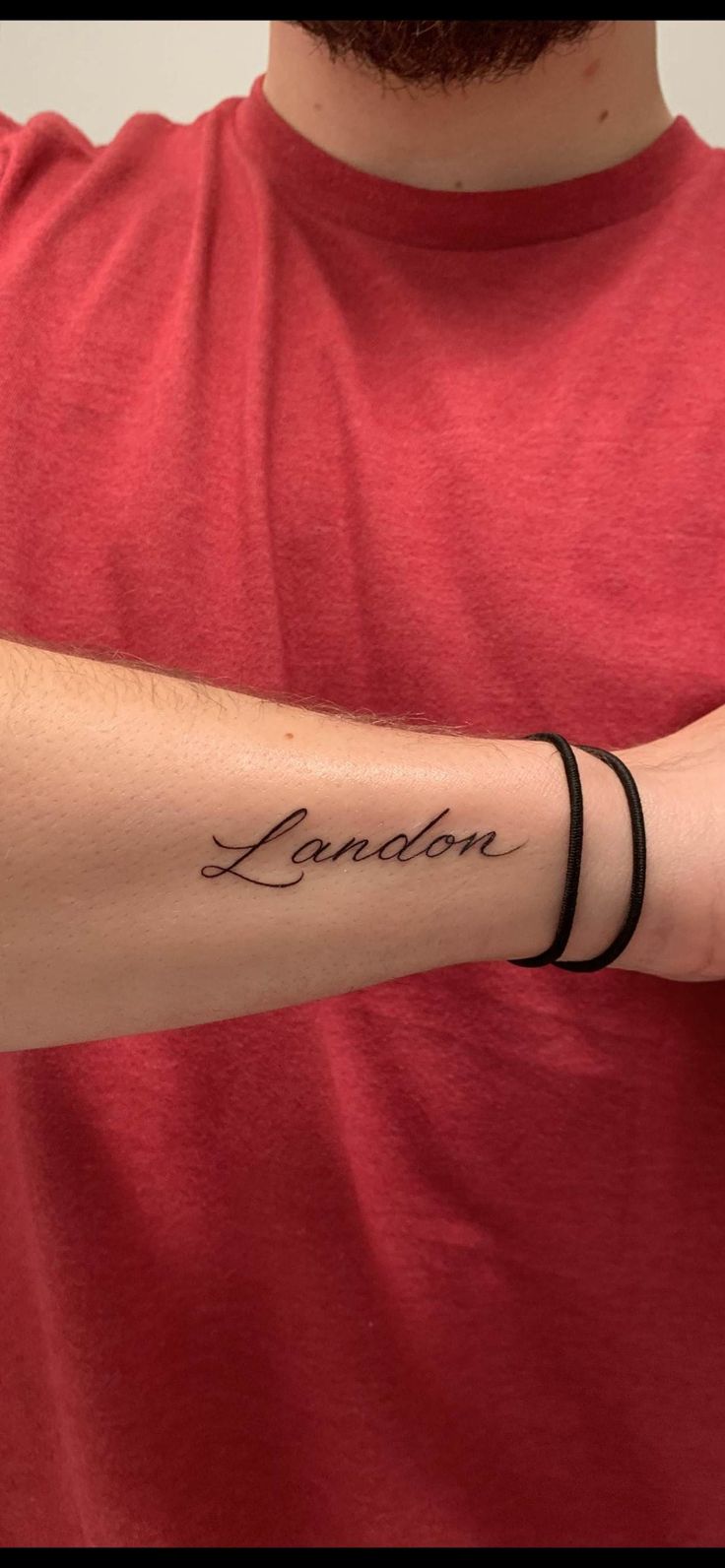 a man with a tattoo on his arm that reads london and has the word london written across it