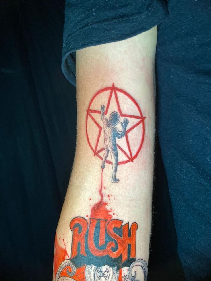 a person with a tattoo on their arm that reads rush and has an image of a man holding a pen