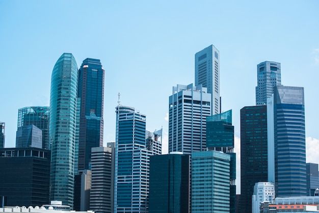 the city is full of tall buildings and boats on the water in front of them