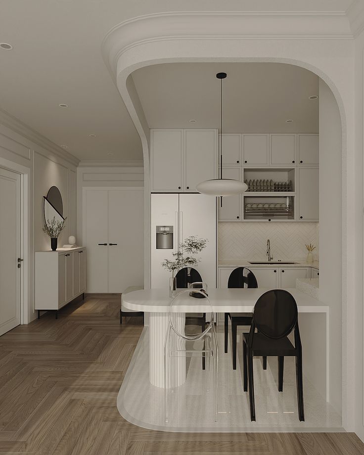 a white kitchen and dining room with hardwood floors, an archway leading to the living room