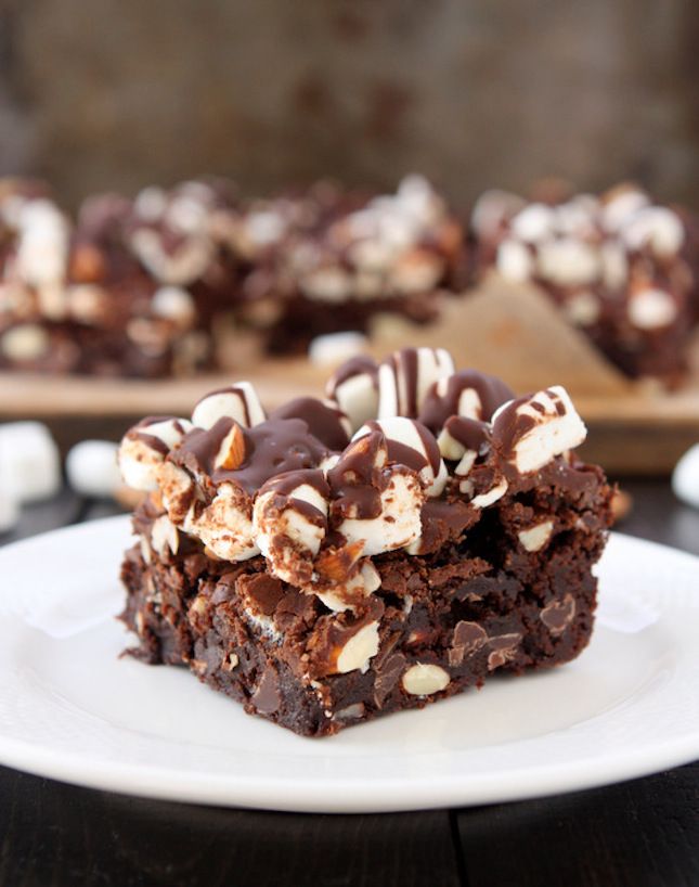 there is a piece of chocolate cake on the plate with marshmallows around it