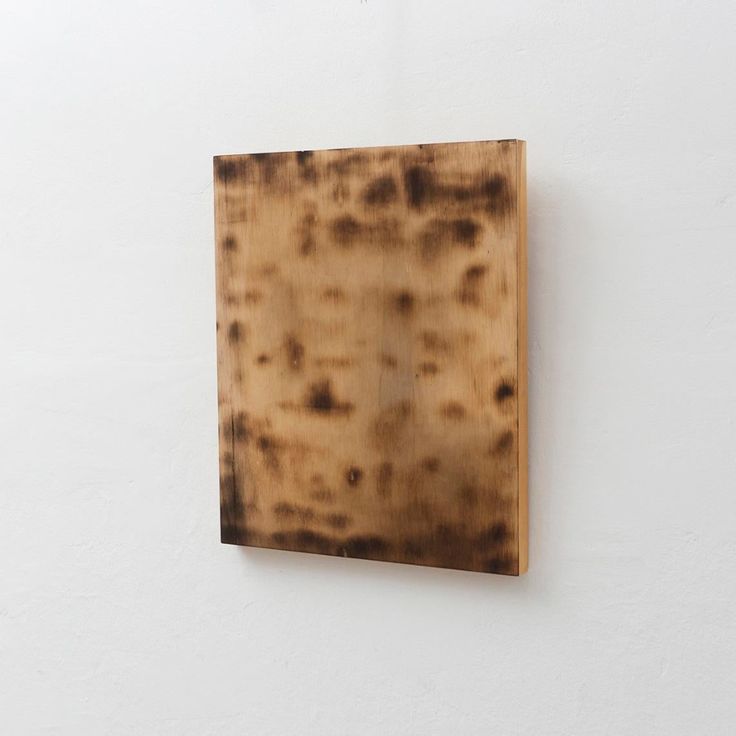 a piece of wood sitting on top of a white wall