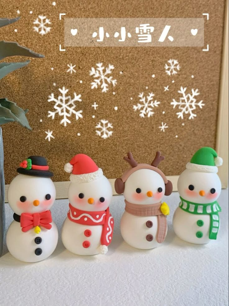 a group of snowmen standing next to each other in front of a wall with snowflakes on it