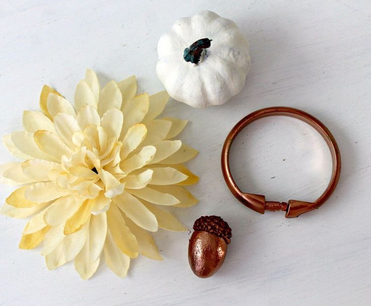 three different types of flowers are arranged on a white surface, including an acorn and a ring