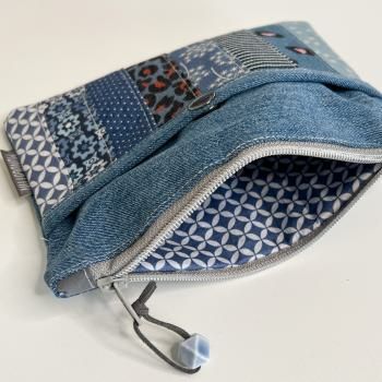 the zippered pouch is made from denim and has an animal print pattern on it